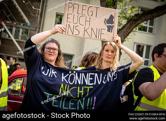 01 June 2022, North Rhine-Westphalia, Cologne: Carrying a placard reading ""Take care of your knee"", two women wearing a T-shirt reading ""We can't divide""...
