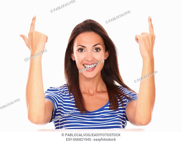 Smiling friendly lady with fingers pointing up gesturing a handgun in white background - copyspace