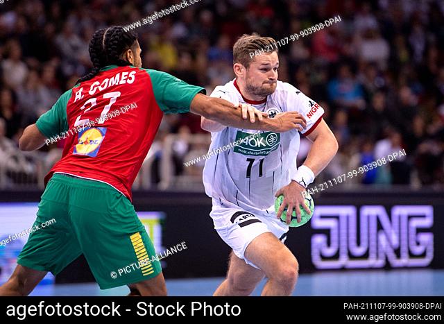 07 November 2021, North Rhine-Westphalia, Duesseldorf: Handball: International match, Germany - Portugal, ISS Dome. Portugal's Andre Gomes (l) and Germany's...
