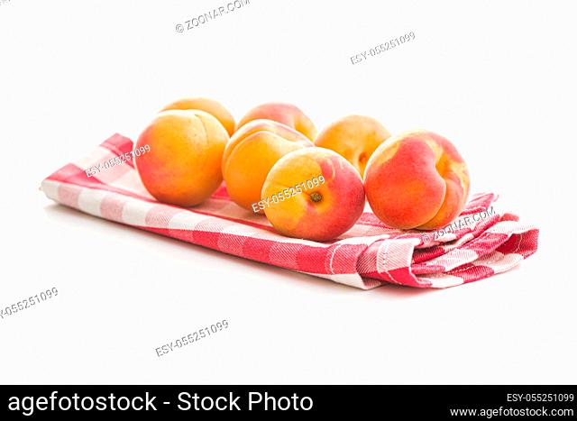 Sweet apricot fruits on checkered napkin isolated on white background