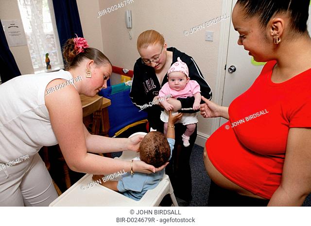 Pregnant young woman with her friends and their babies