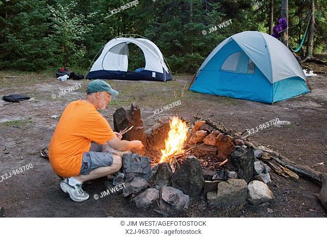 Quetico Provincial Park, Ontario - Tony Rothschild makes a campfire while on a canoe camping trip