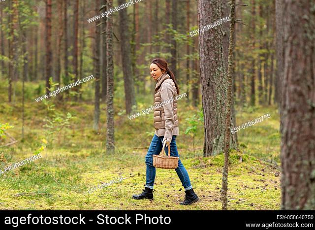 young woman picking mushrooms in autumn forest