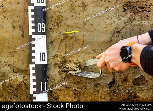 27 April 2022, Thuringia, Pfiffelbach: An employee of the Forest Research Center takes a forest soil sample from a soil profile