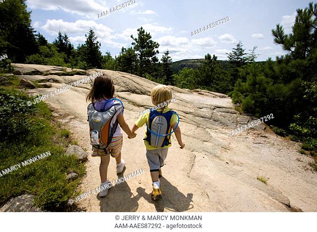 Two young hikers (girl age 5 and boy age 3) on the South Bubble in Maine's Acadia National Park. Near Jordan Pond