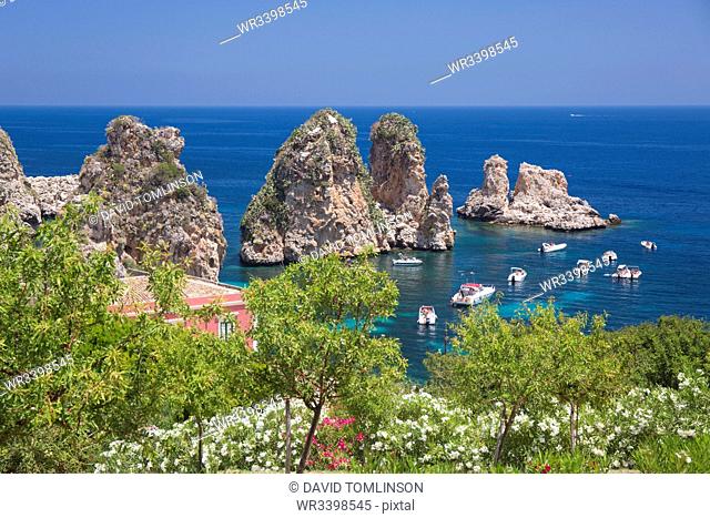 View from hillside over tranquil cove to the Faraglioni, a series of offshore rock stacks, Scopello, Trapani, Sicily, Italy, Mediterranean, Europe