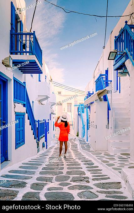 Mykonos Greece, Young woman in dress at the Streets of old town Mikonos during a vacation in Greece, Little Venice Mykonos Greece