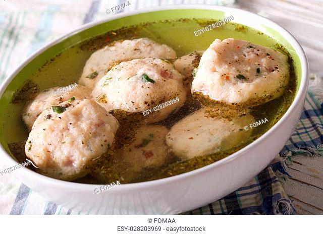 bread dumplings in a broth in a bowl close up. horizontal