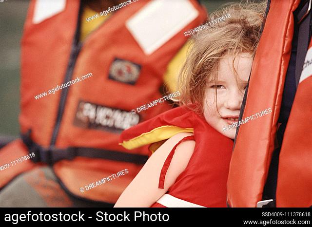 Young girl and parent wearing life-jackets