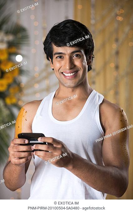Man text messaging on a mobile phone and smiling