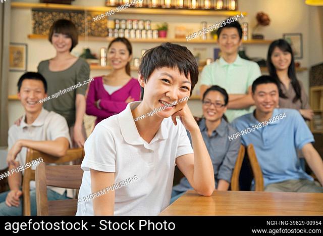 Portrait of young woman with group of friends at a coffee shop