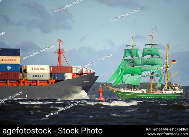 14 October 2020, Schleswig-Holstein, Laboe: The three-master ""Alexander von Humboldt 2"" sails past a container ship near the coast near Laboe on her return...
