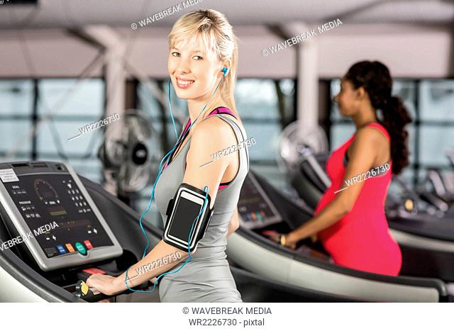Smiling woman on treadmill with headphones