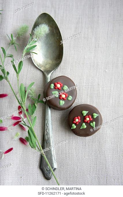 A silver spoon and pralines decorated with flowers