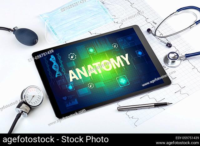 Tablet pc and medical stuff with ANATOMY inscription, prevention concept