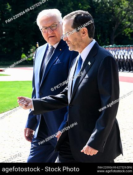 04 September 2022, Berlin: German President Frank-Walter Steinmeier (l) welcomes Izchak Herzog, President of Israel, with military honors in the park of...