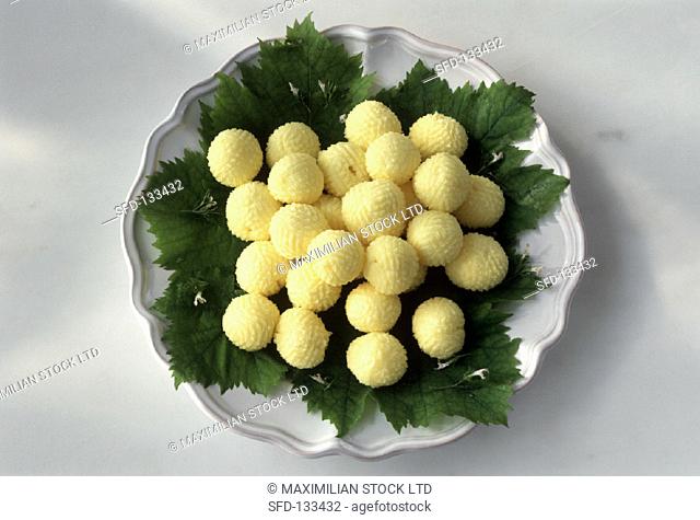 Butter balls on vine leaves in white bowl