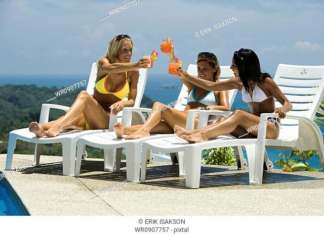 Three women relaxing on deck loungers