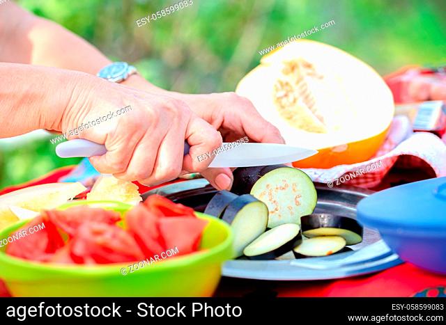 Closeup of senior female chopping vegetables food ingredients in the outdoor