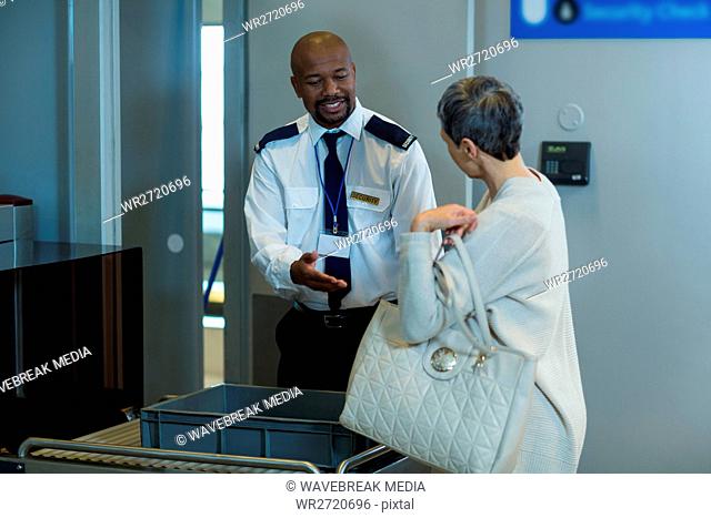 Commuter getting a bag checked from airport security officer