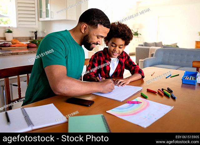 Father helping son with painting at home