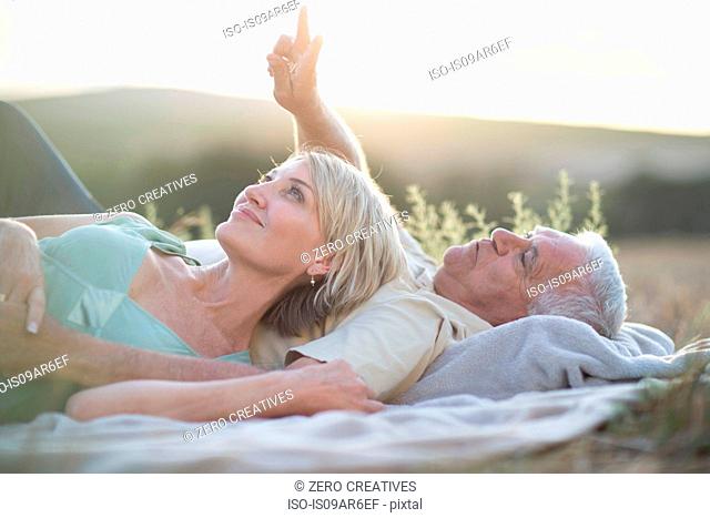 Mature couple lying on blanket looking up