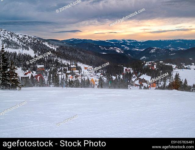 Picturesque winter windy and cloudy morning alps. View of famous Ukrainian Dragobrat ski resort from Svydovets mountain ridge