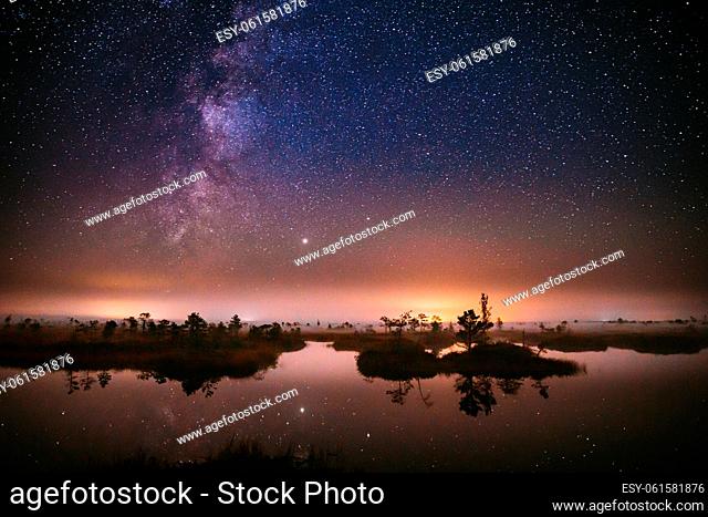 Real Colorful Night Stars Above Swamp. Milky Way Galaxy In Night Starry Sky Above Rural Landscape In Summer Season. Amazing Glowing Stars Effects Above...