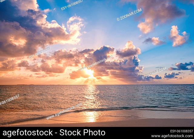 sunset sky with colorful clouds over ocean and beach -