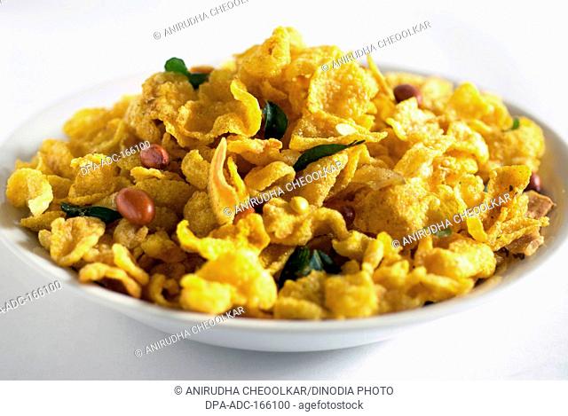 Snacks ; corn flakes fried yellow maka chivda served in dish on white background
