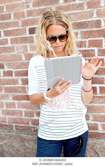 Blond woman using digital tablet