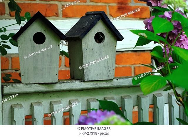 Two birdhouses on fence