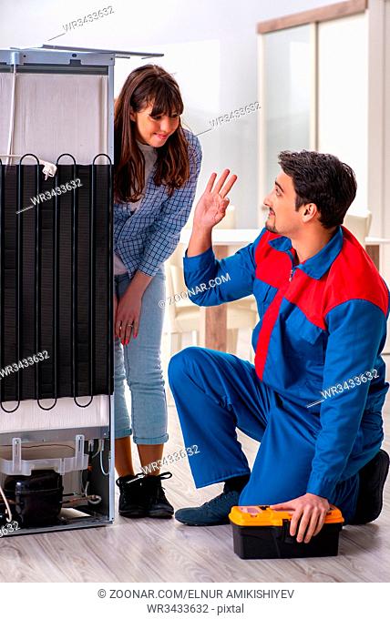 Man repairing fridge with customer