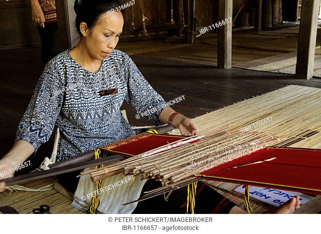 Woman on a loom in the Sarawak Cultural Village near Kuching, Sarawak, Borneo, Malaysia, Southeast Asia