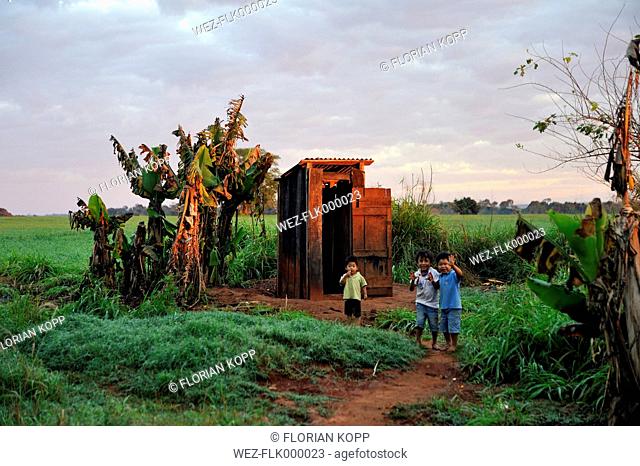Paraguay, Caaguazu, Jaguary, Guarani boys in front of public toilette