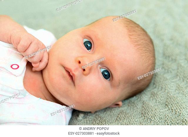 Portrait Photo On An Adorable Innocent Child Lying And Pondering On Wool Blanket