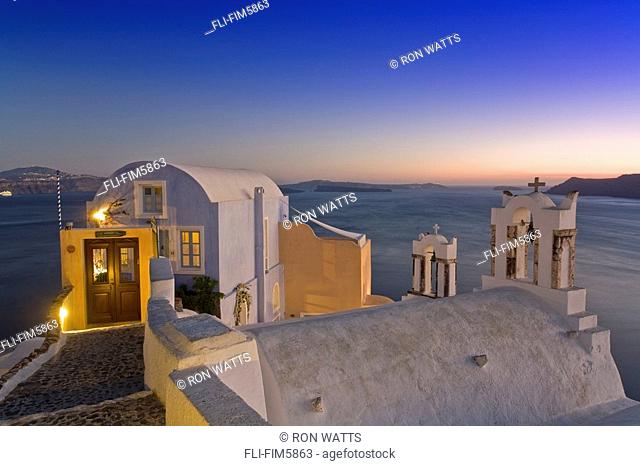 View of a Building in the Village of Oia perched on steep Cliffs overlooking the submerged Caldera at Sunset, Santorini, Greece