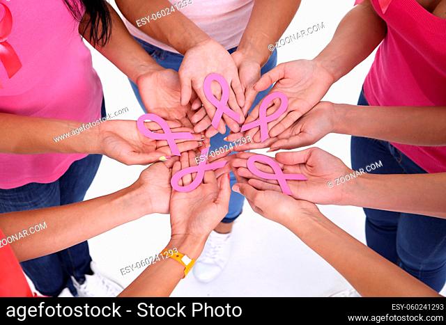 healthcare, people and medicine concept - close up of women hands with cancer awareness ribbons over white background
