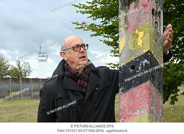 30 September 2019, Hessen, Rasdorf: Berthold Dücker grabs a weathered border post at the border memorial Point Alpha. Point Alpha is considered one of the most...