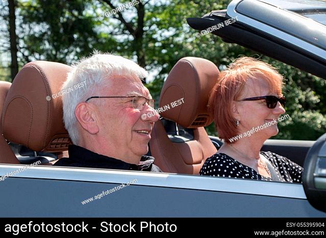 Happy senior couple in the car on a sunny day