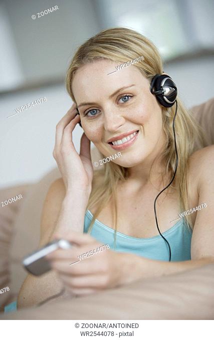 Young woman with MP3 Player lying on couch
