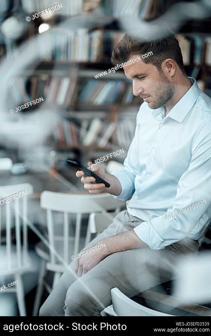 Businessman using mobile phone while sitting at cafe