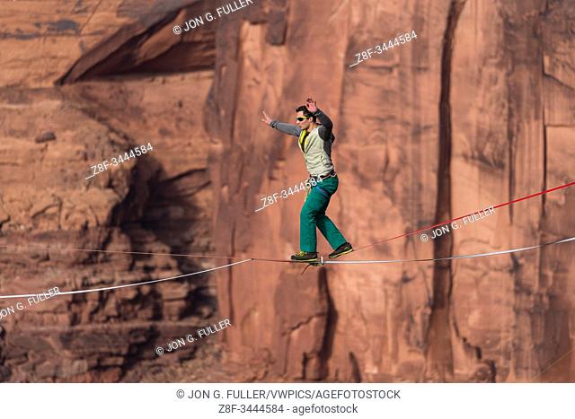 A young man slacklining or highlining hundreds of feet above Mineral Canyon near Moab, Utah during a highline gathering