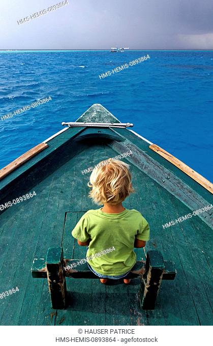 Maldives, Atoll Baa, Soneva Fushi hotel, child on a boat