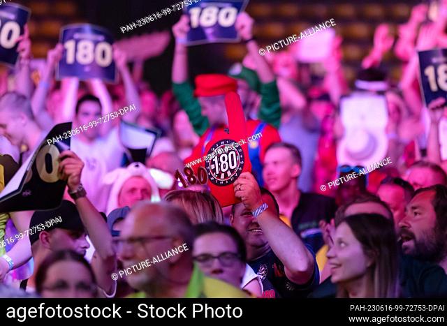 15 June 2023, Hesse, Frankfurt/Main: Darts: World Team Championship, group stage: spectators hold up dartboards with the number 180