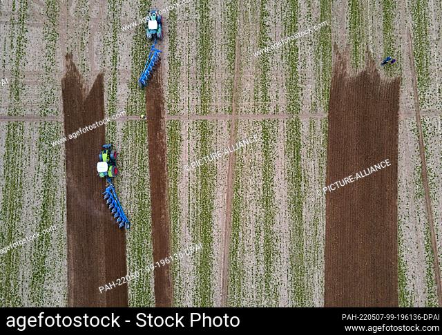07 May 2022, Mecklenburg-Western Pomerania, Brüsewitz: Tractors pull the plows across the field under the critical gaze of judges at the 19th West Mecklenburg...