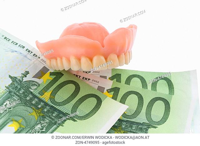 Gebiss und Euroscheine, Symbolfoto für Zahnersatz, Behandlungskosten und Zuzahlung