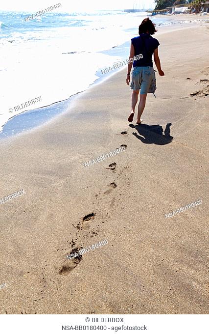 A woman walks on the beach.Recreation vacation