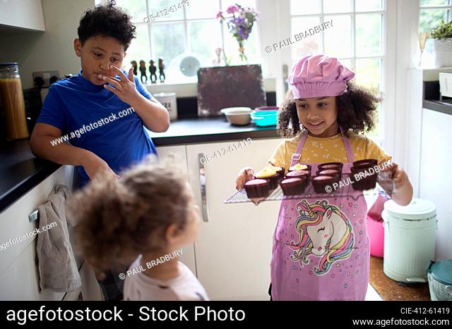 Kids baking cupcakes in kitchen