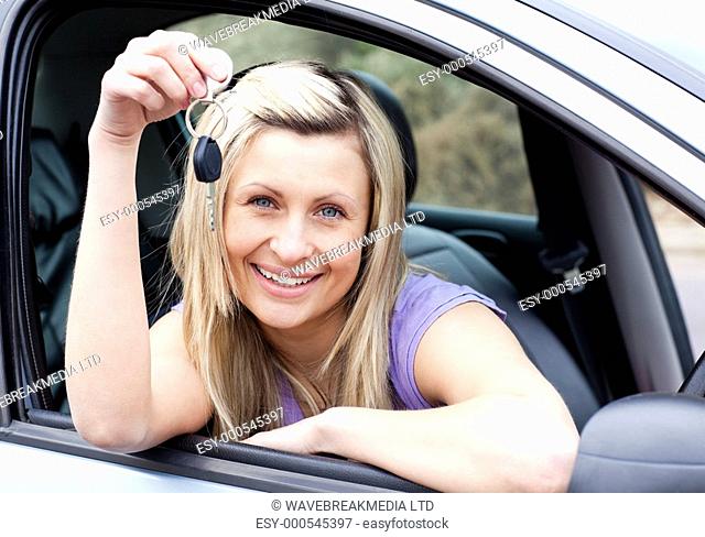 Portrait of a happy young driver holding a key after bying a new car